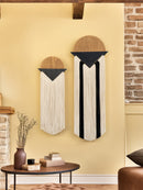 Decorative wall hangings on a yellow wall with a brick fireplace.