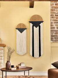 Decorative wall hangings on a yellow wall with a brick fireplace.