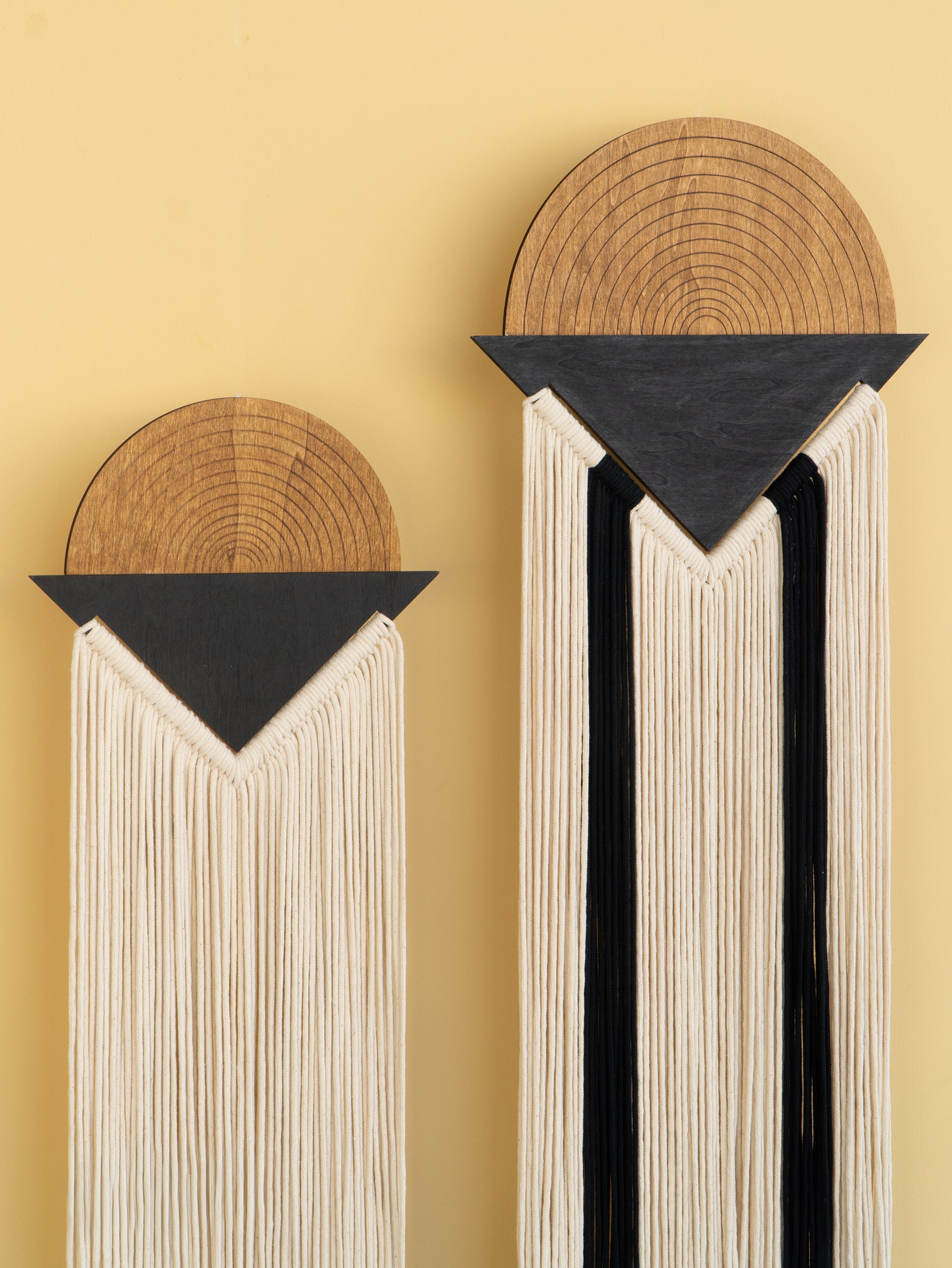 Decorative wall art with wooden and black elements on a yellow background
