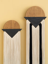 Decorative wall art with wooden and black elements on a yellow background