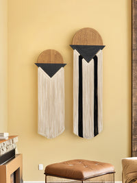 Decorative wall hangings with geometric designs on a yellow wall.