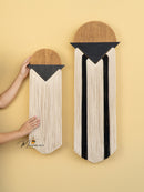 Two wall-mounted decorative items with geometric patterns on a yellow background