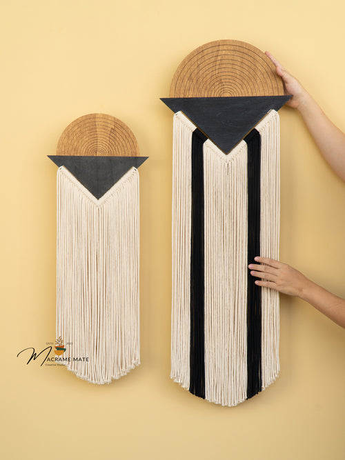 Two wall art pieces made from books with woven patterns on a yellow background.