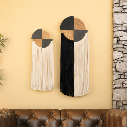 Decorative wall art with geometric design on a yellow wall next to a stone wall and brown sofa.