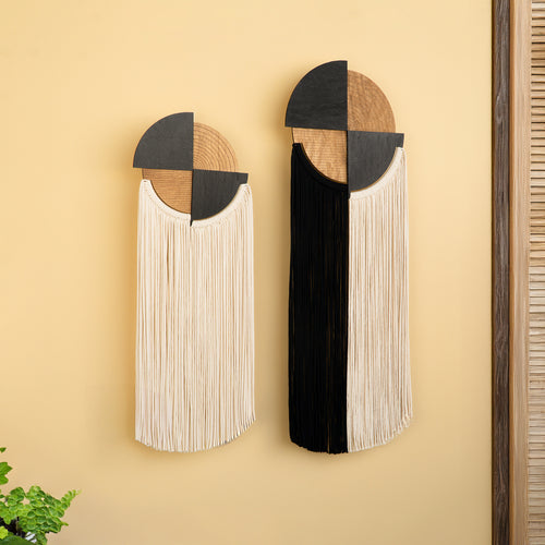 Two decorative wall art pieces with geometric designs on a beige wall.