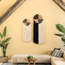 Decorative wall art pieces on a yellow wall with a beige sofa and plants.