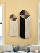 Decorative wall hangings with geometric design on a beige wall.