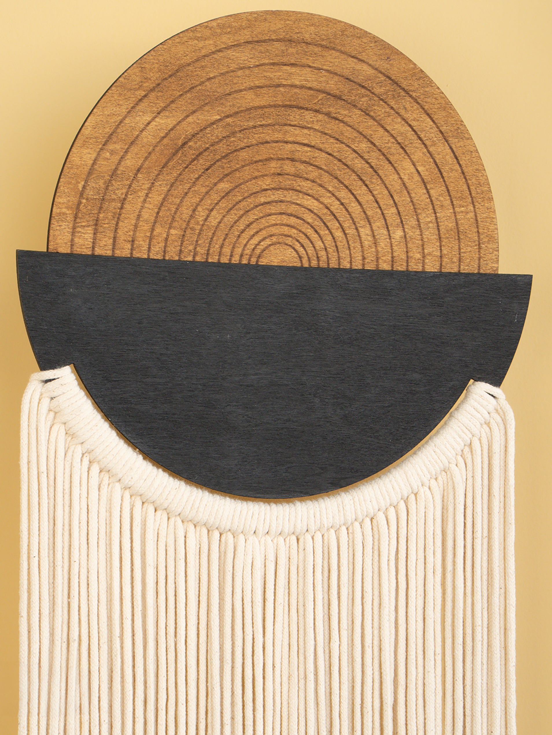 Abstract art piece with concentric circles and fringed texture on a beige background