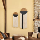 Decorative wall art pieces on a yellow wall with a stone fireplace and brown furniture.