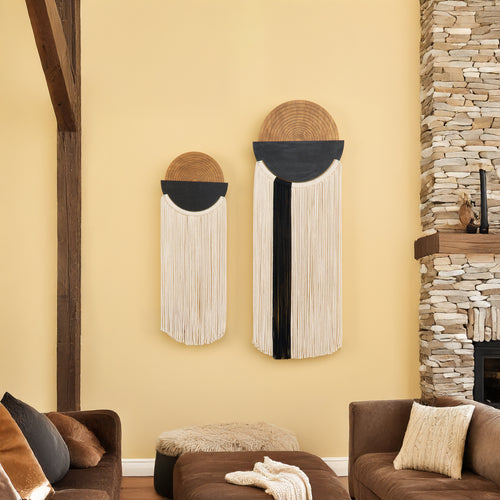 Decorative wall art pieces on a yellow wall with a stone fireplace and brown furniture.