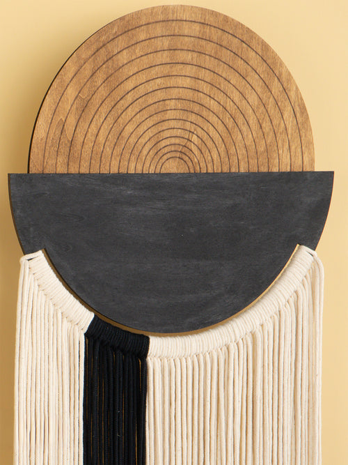 Decorative wall piece with circular wooden top, black semi-circle, and beige base on a beige background
