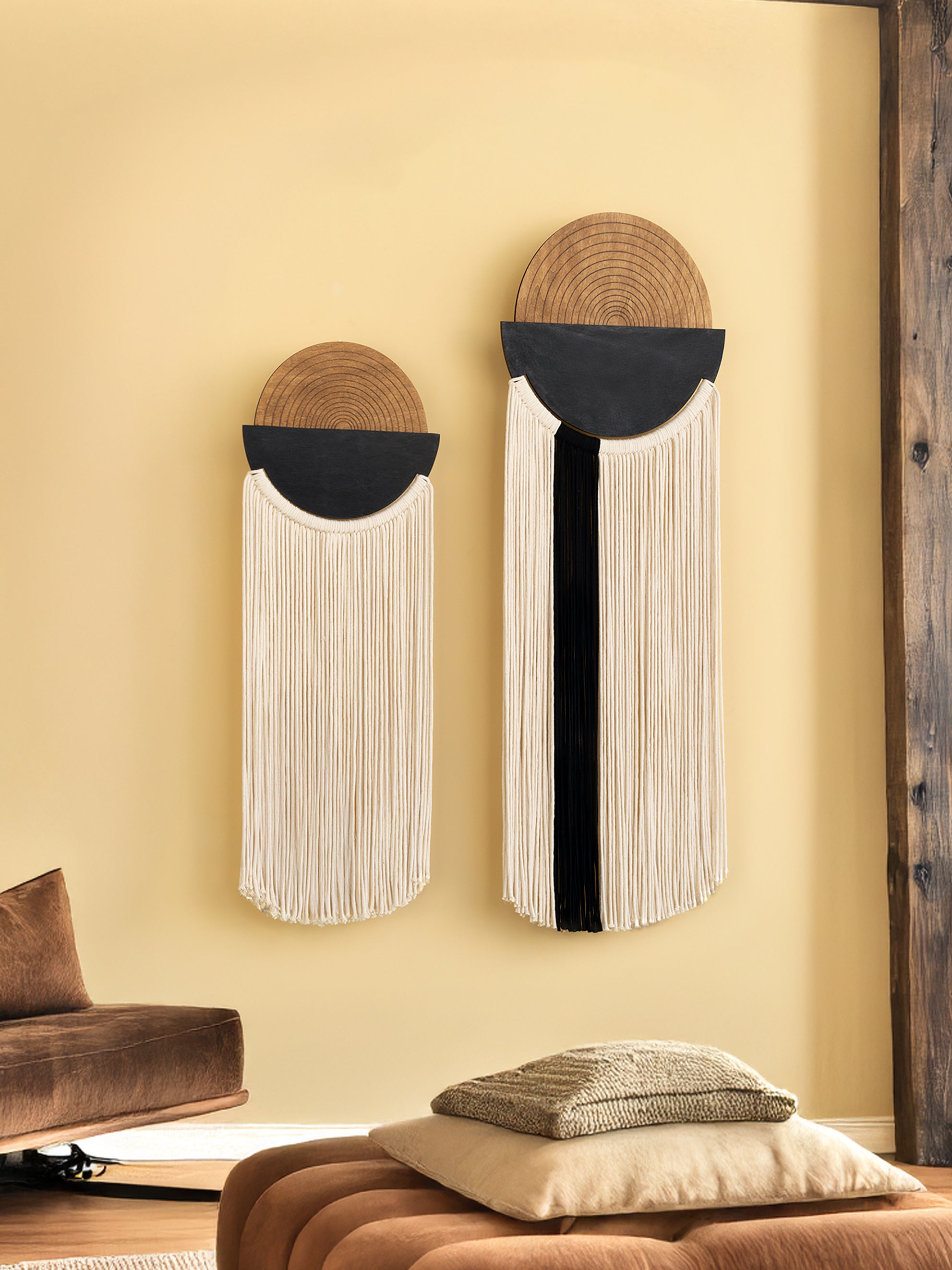 Two decorative wall hangings with circular designs on a beige wall.