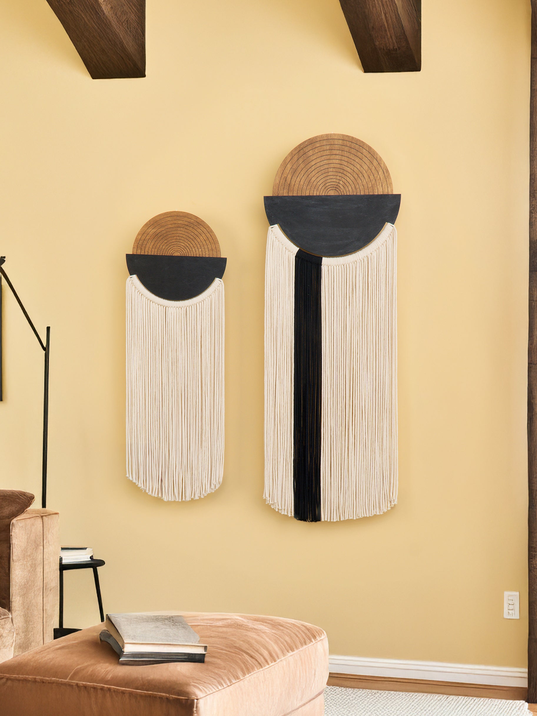 Two decorative wall hangings with circular designs on a beige wall.