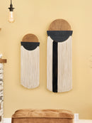 Two wall art pieces with circular designs and fringe on a yellow wall.