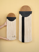 Two wall-mounted woven baskets with black and beige design on a beige background