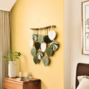 Decorative wall hanging with leaf patterns on a yellow wall in a room.