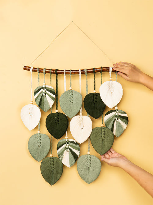 Decorative wall hanging with leaf-shaped ornaments on a yellow background