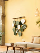 Decorative wall hanging with leaf patterns in a living room setting.