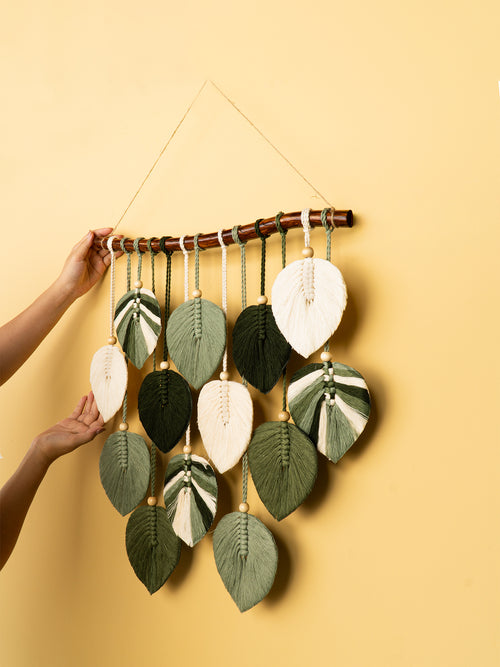 Decorative wall hanging with leaf-shaped elements on a yellow background