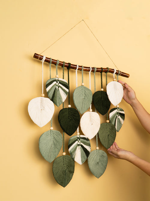 Decorative wall hanging with leaf-shaped fabric pieces on a yellow background