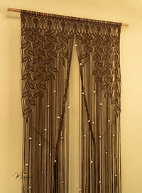 Decorative curtain with macrame design on a beige wall