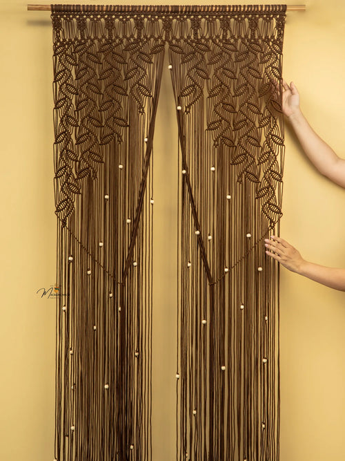 Decorative string curtain with leaf patterns on a yellow wall