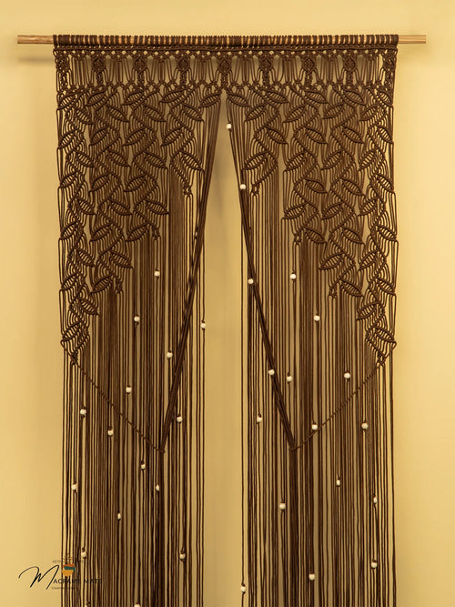 Decorative brown macrame curtain with leaf patterns on a beige background