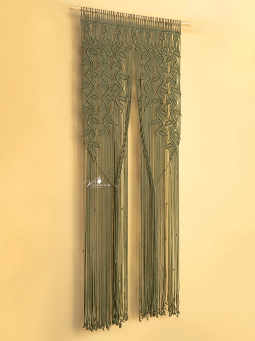 Decorative green curtain with intricate patterns on a beige wall