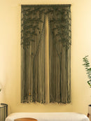 String art wall decoration on a beige wall with a bench and plant in the foreground