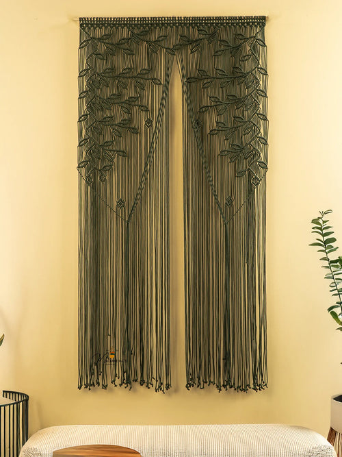 String art wall decoration on a beige wall with a bench and plant in the foreground