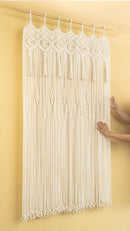 Macrame wall hanging with tassels on a yellow background