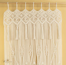 Macrame wall hanging with geometric pattern and tassels on a yellow background