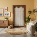 Living room with a macrame door hanging, round jute rug, and wooden furniture.