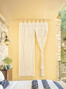 Macrame wall hanging on a yellow wall in a bedroom.