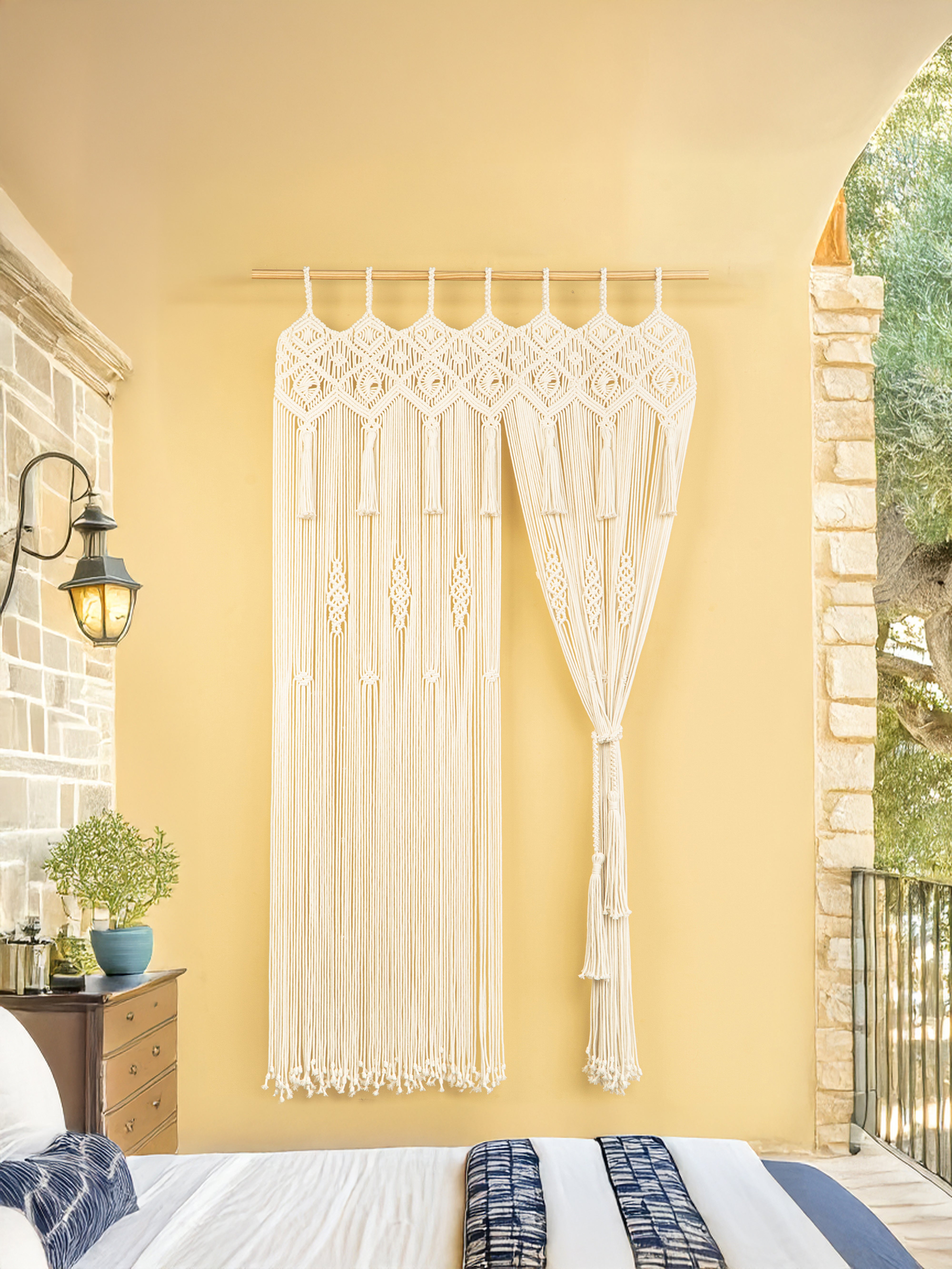 Macrame wall hanging on a yellow wall in a bedroom.