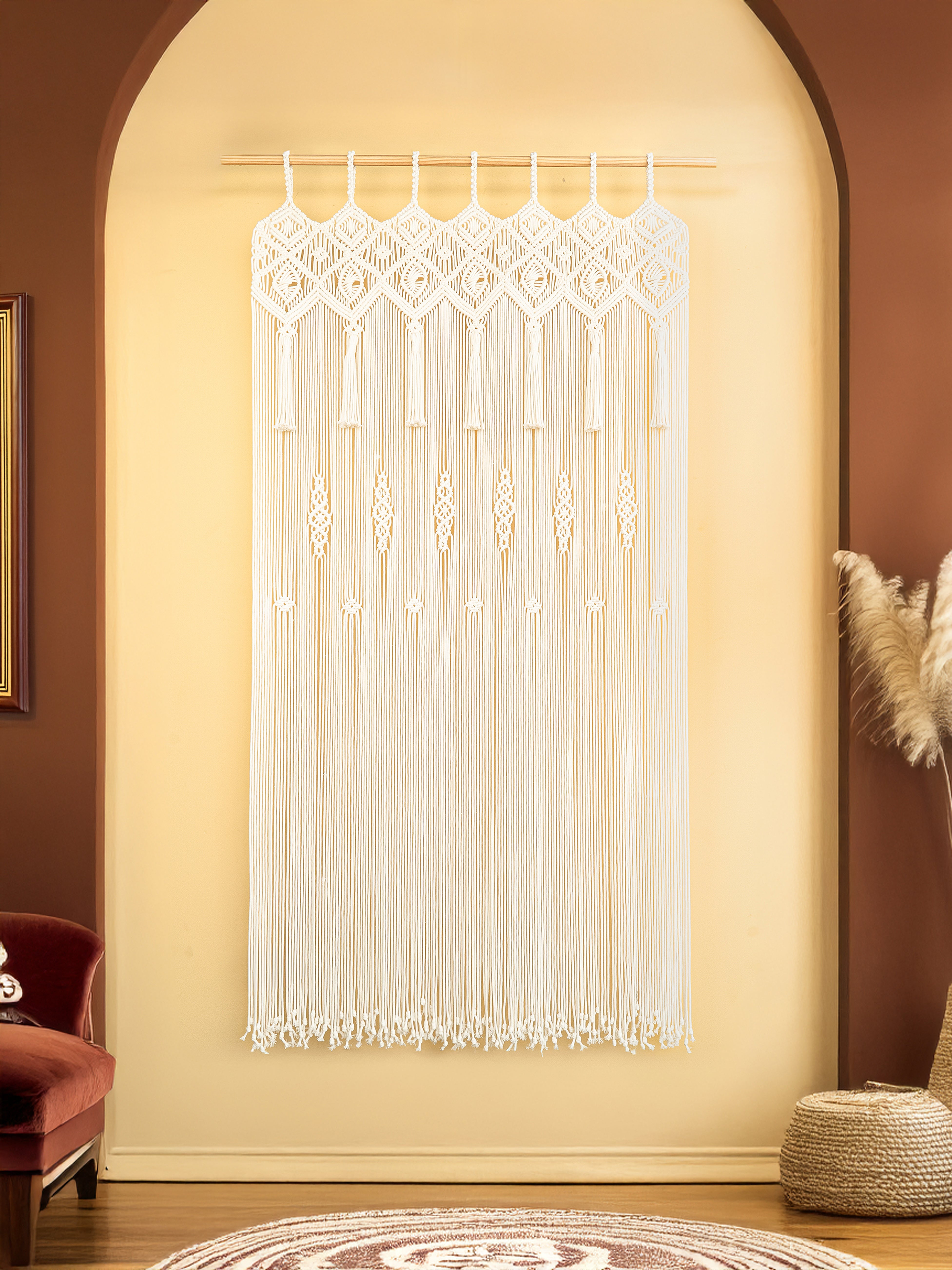 Decorative string curtain hanging in a room with a red armchair and brown walls.