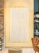 Decorative string curtain hanging in a room with a brick wall and bookshelf.