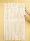 Macrame string curtain with geometric patterns on a yellow background