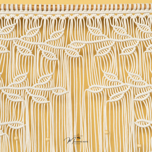 A close-up of a textured fabric or wallpaper featuring a stylized tree design with orange-brown branches and leaves on a warm beige background, accented with small white beads.