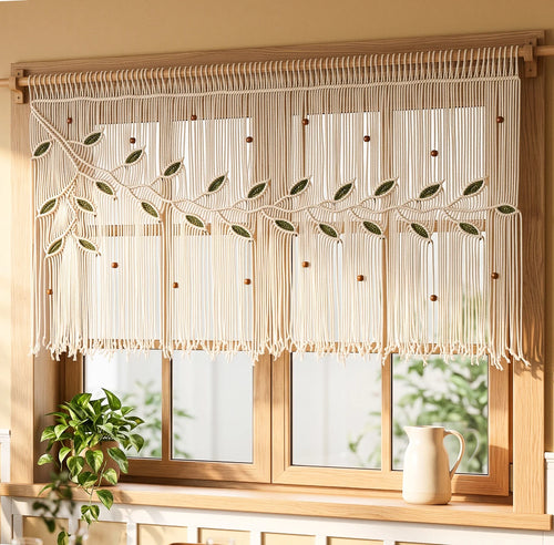 A decorative window curtain made of hanging string beads with a dark green leaf vine design and a large gold flower accent, shown hanging in front of a white-framed window with a garden view.