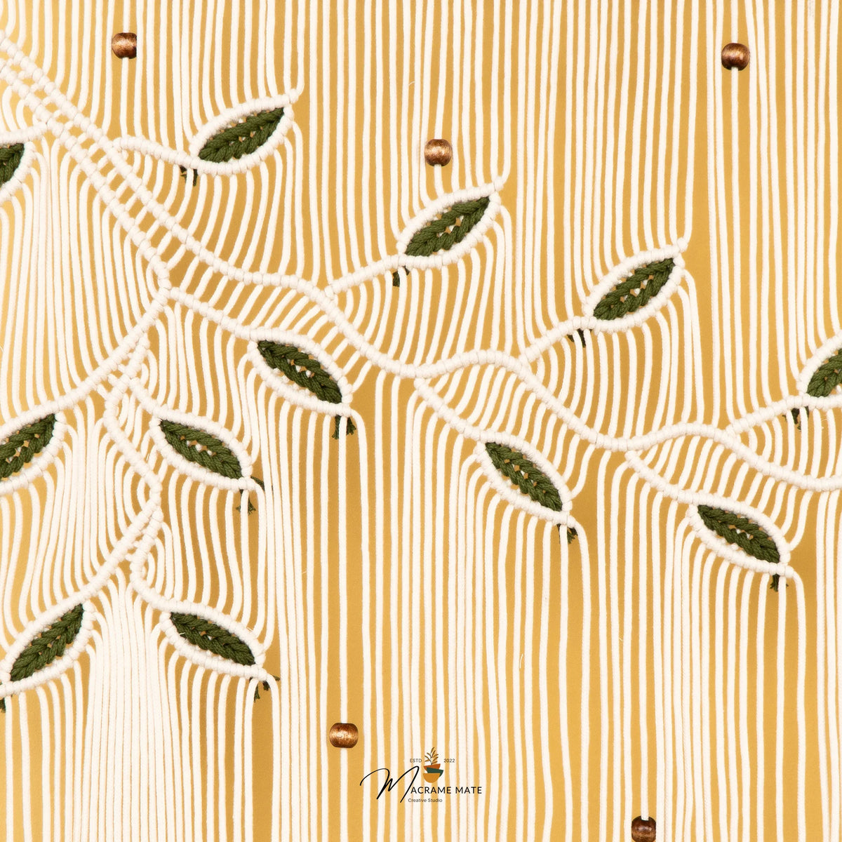 A close-up of a textured fabric featuring a warm mustard yellow background with vertical ribbed stripes and a cream-colored embroidered leaf pattern.
