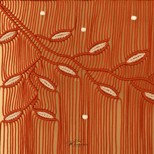 A close-up of a patterned fabric featuring vertical olive green stripes on a warm mustard-yellow background, decorated with embroidered dark green leafy vines and pink flower buds, accented with small white pearl-like beads.