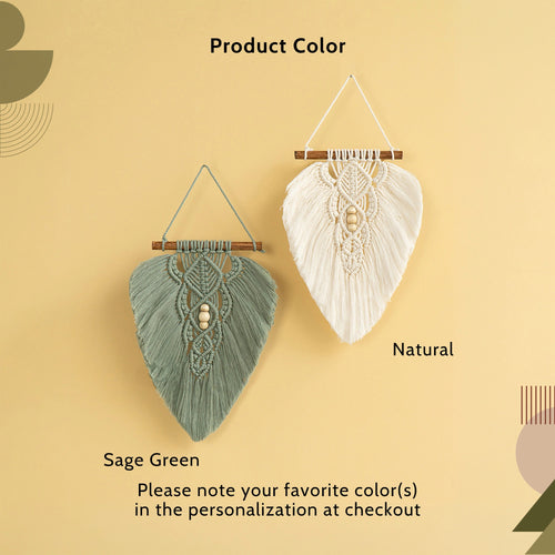 Two macrame wall hangings displayed against a warm beige background, labeled 'Product Color' with options 'Sage Green' and 'Natural'. The left hanging is sage green with a central wooden bead, and the right hanging is natural cream with a central wooden bead.