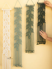 Four macrame wall hangings in different patterns on a yellow wall.