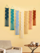 Colorful wall hangings on a yellow wall with a chair and table in the foreground.