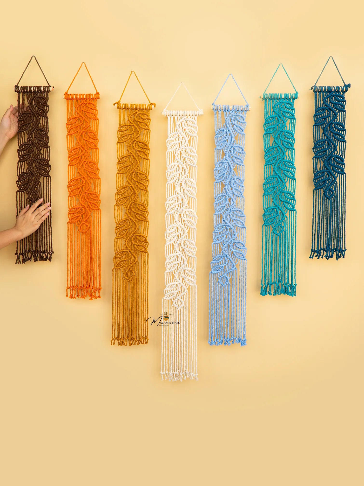Set of six woven wall art pieces in various colors on a yellow background