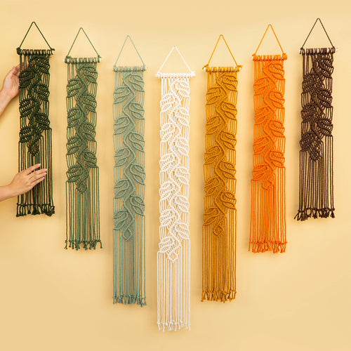 Set of seven narrow leaf vine macrame wall hangings displayed in botanical green and warm earth tone gradients