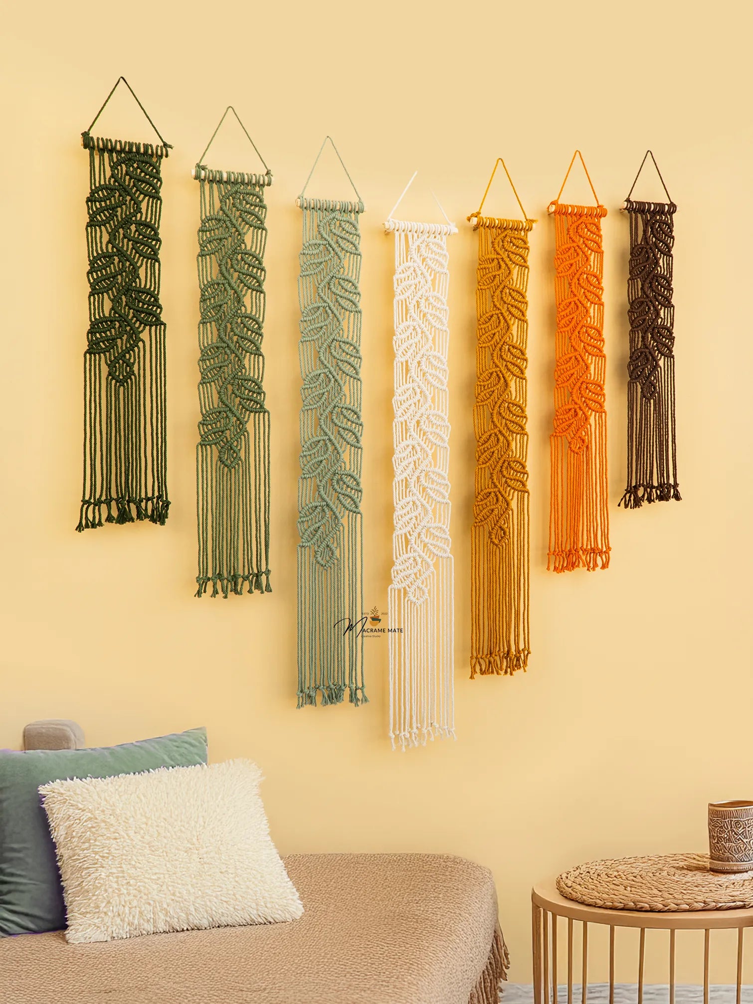 Set of six woven wall hangings in various colors on a yellow wall.
