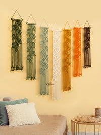 Set of six woven wall hangings in various colors on a yellow wall.