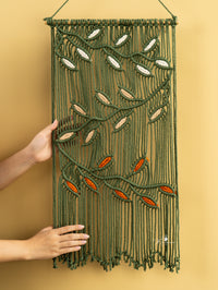 Macrame wall hanging with leaf patterns on a yellow background